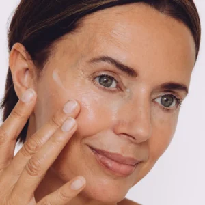 Woman applying CellDerma skincare serum