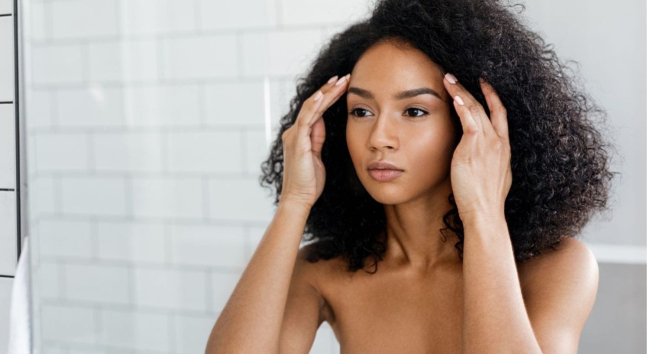 stressed skin model looking in the mirror