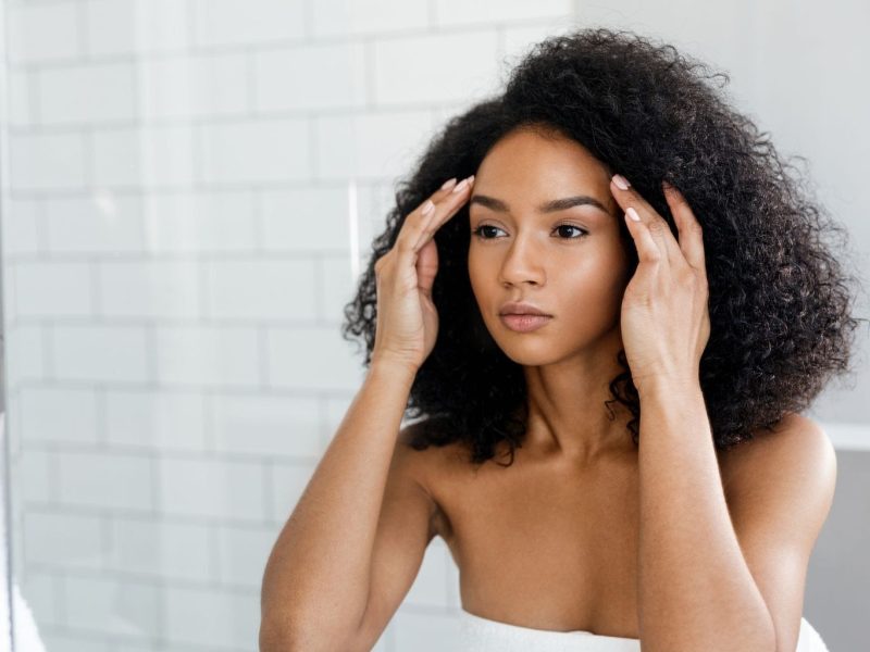 stressed skin model looking in the mirror