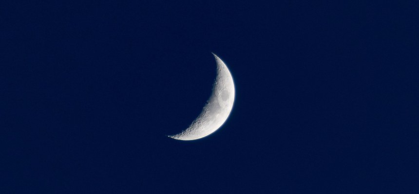 A photo of crescent moon in a dark blue sky