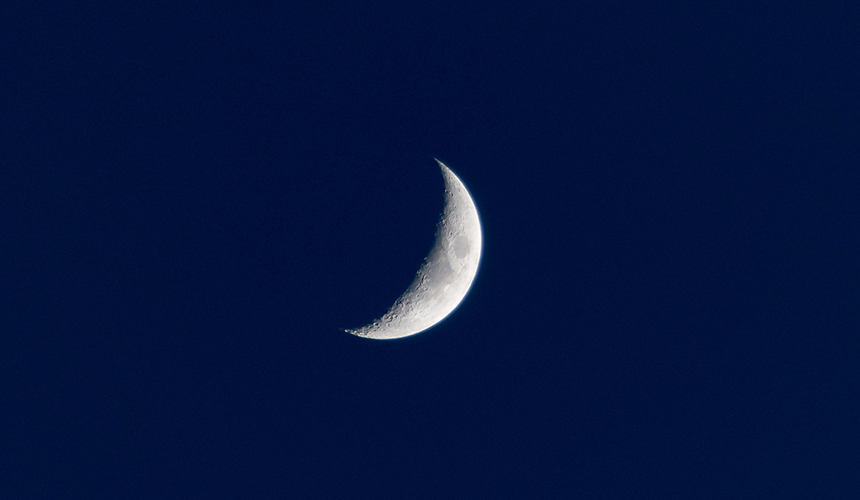 A photo of crescent moon in a dark blue sky