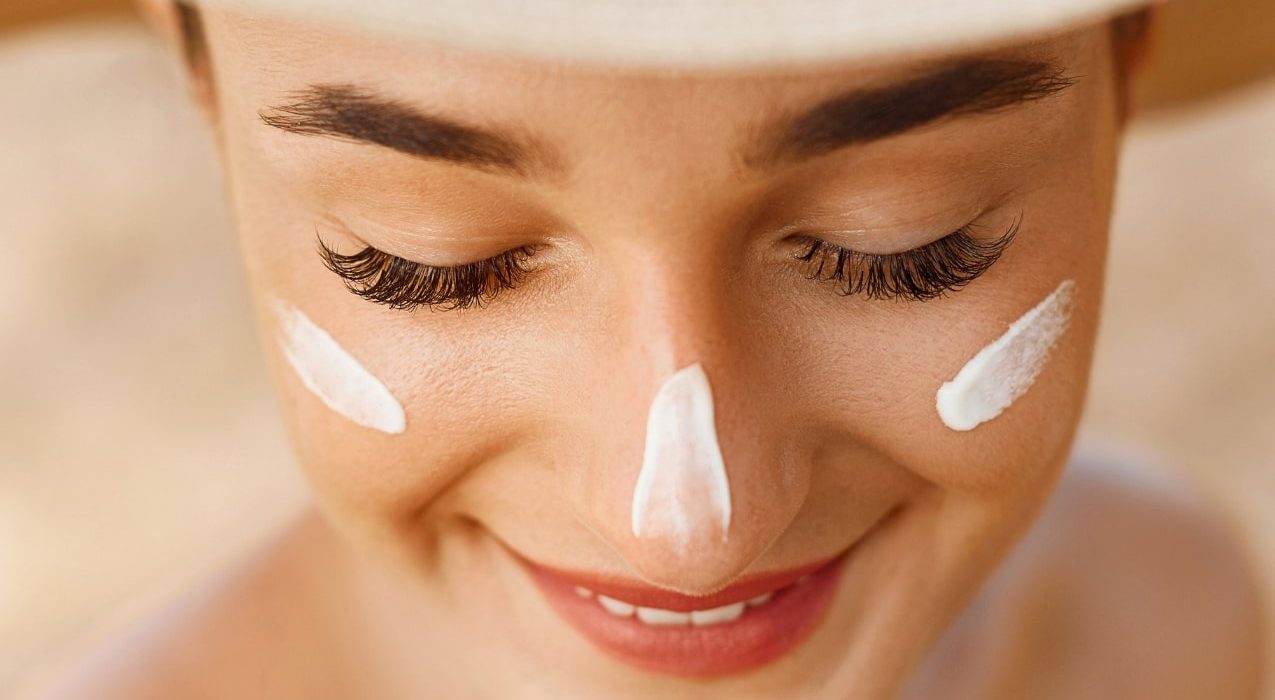 spf face cream on womans cheeks and nose
